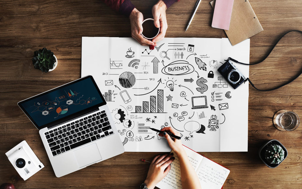 Overhead view of two people writing a business plan