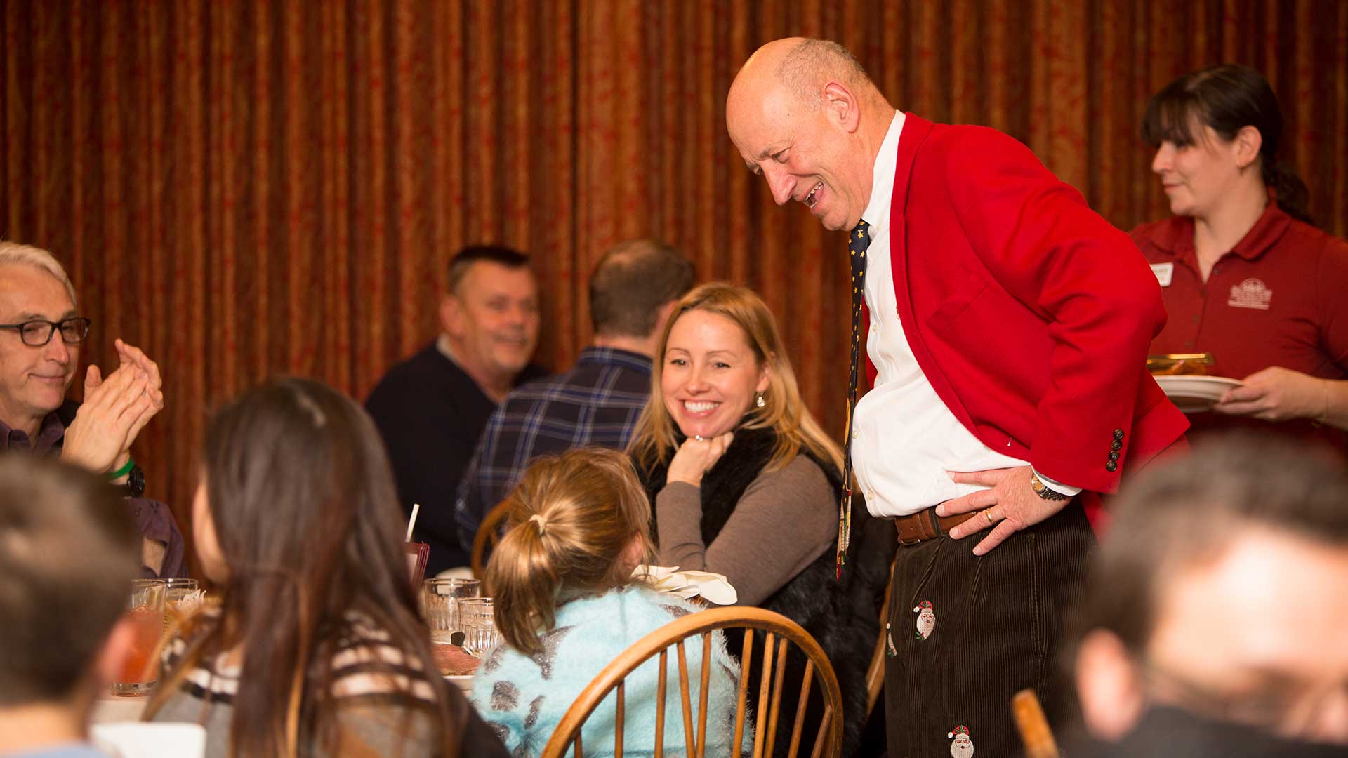 Man talking to family at a dining table.