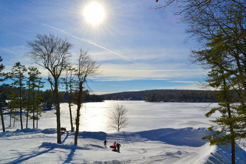 Photo of snowy landscape and people enjoying Poconos winter activities.