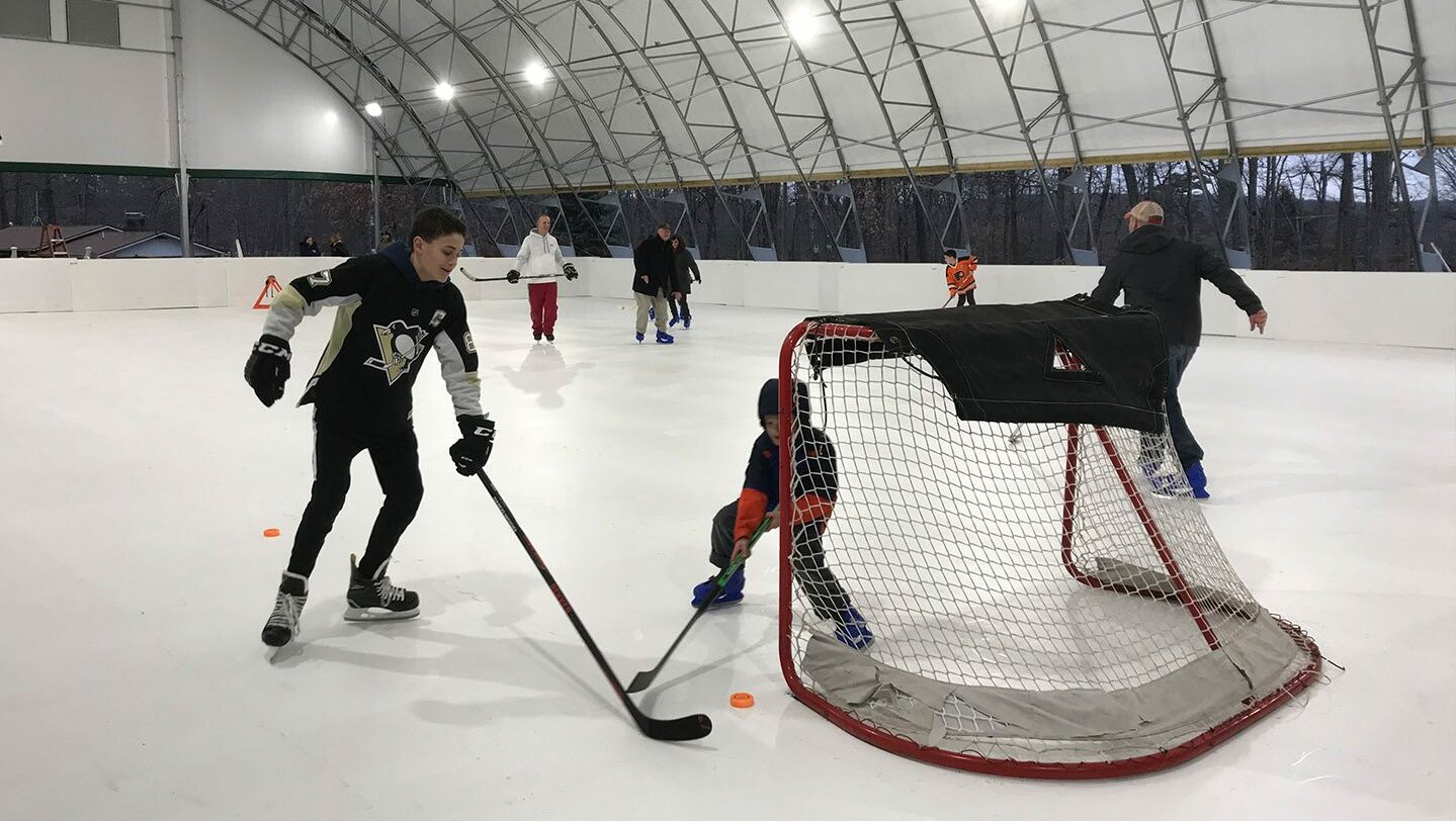 Guests having a hockey scrimmage on the covered ice rink.