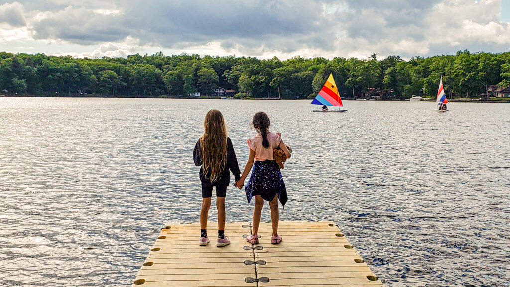 Children hold hands on dock