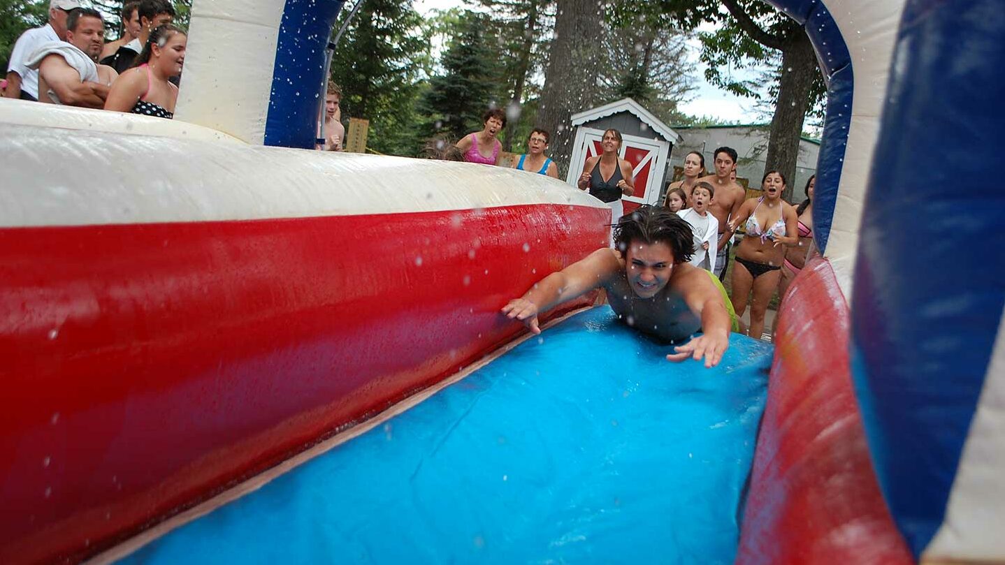 Man jumping on an inflatable water slide.