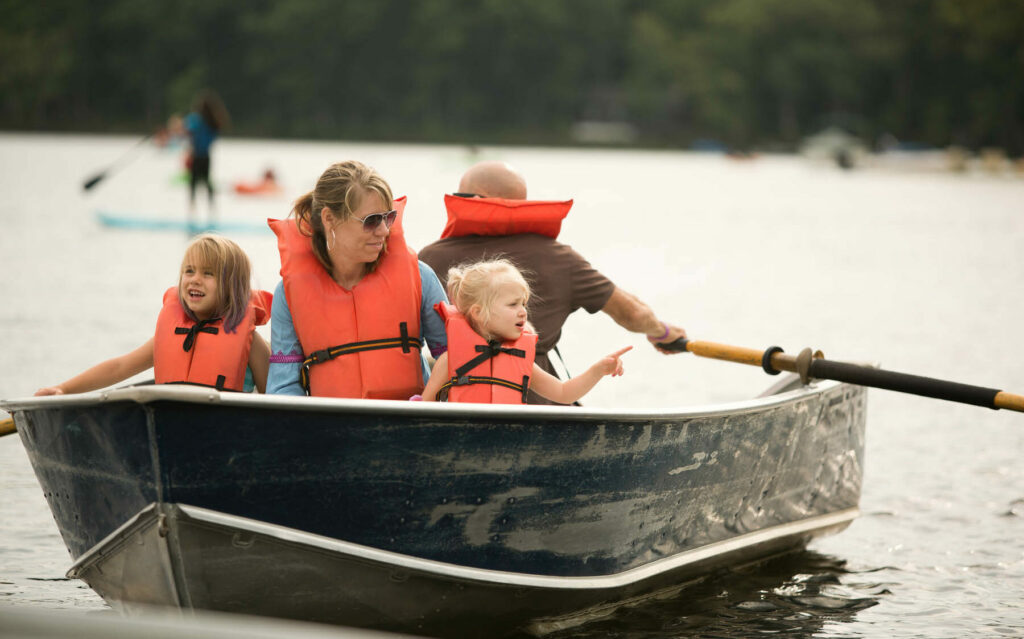 Family in a rowboat. Everyone wearing lifevests.