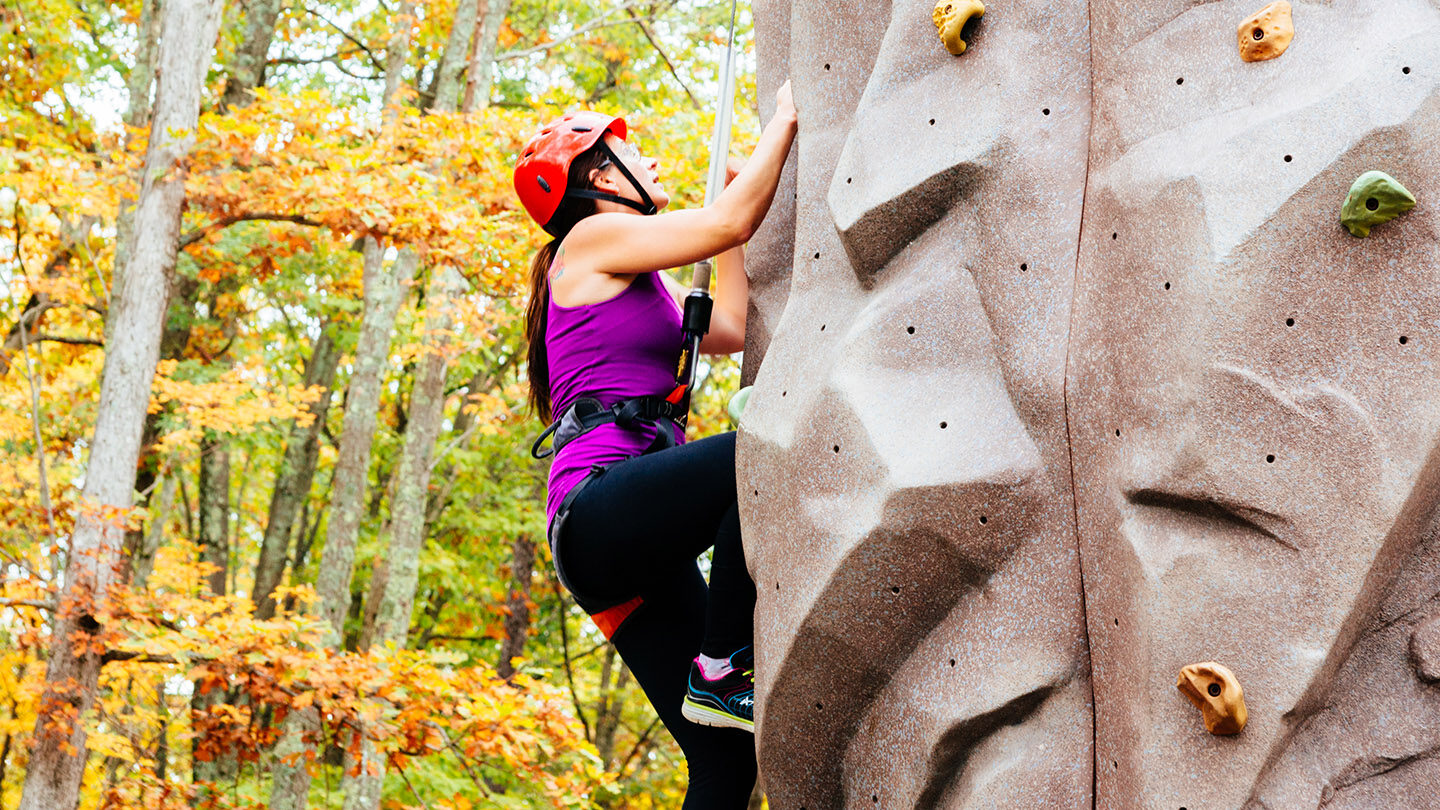 Woman on outdoor climbing wall.