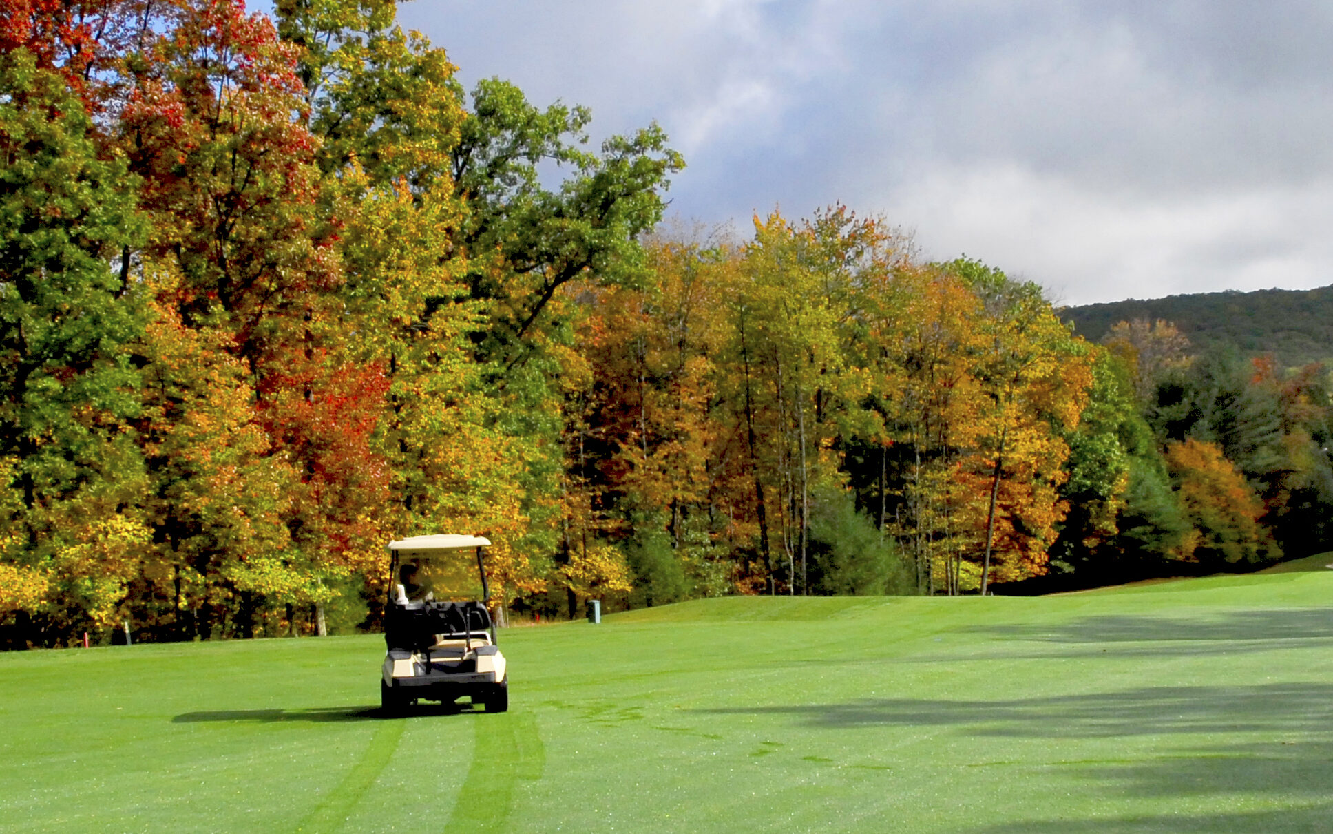 Golf cart on the course in autumn.