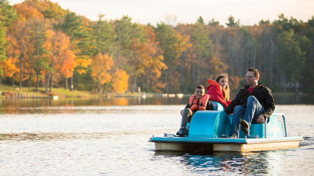 A family out on a boat on a lake near a top Poconos all inclusive family resort.