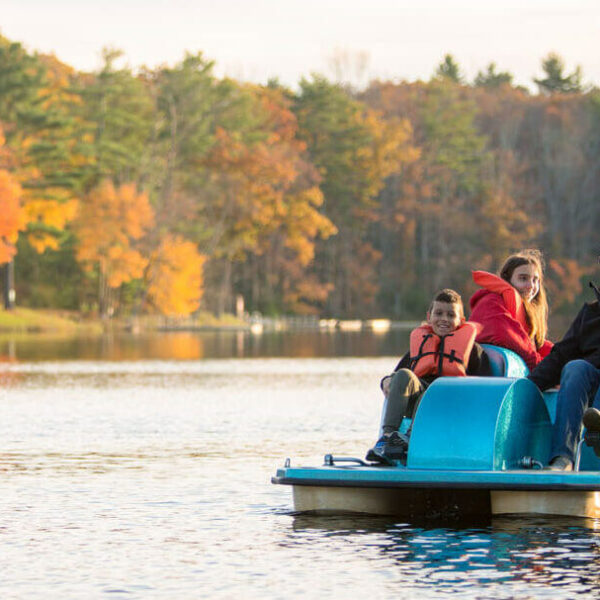 A family out on a boat on a lake near a top Poconos all inclusive family resort.