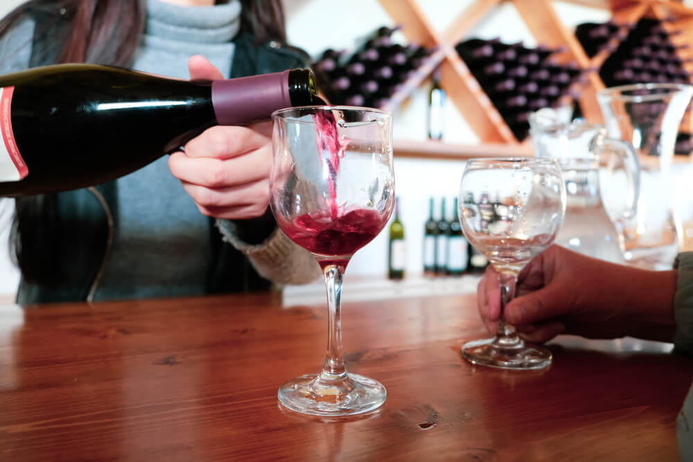 A woman pouring a glass of wine at one of the wineries in the Poconos.