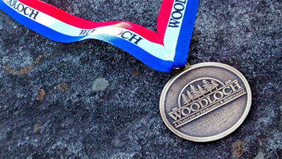 Woodloch OLympics medal laying on a rock.