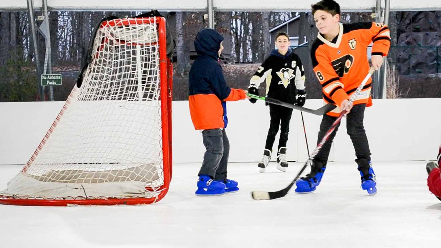 Group of young people playing hockey.