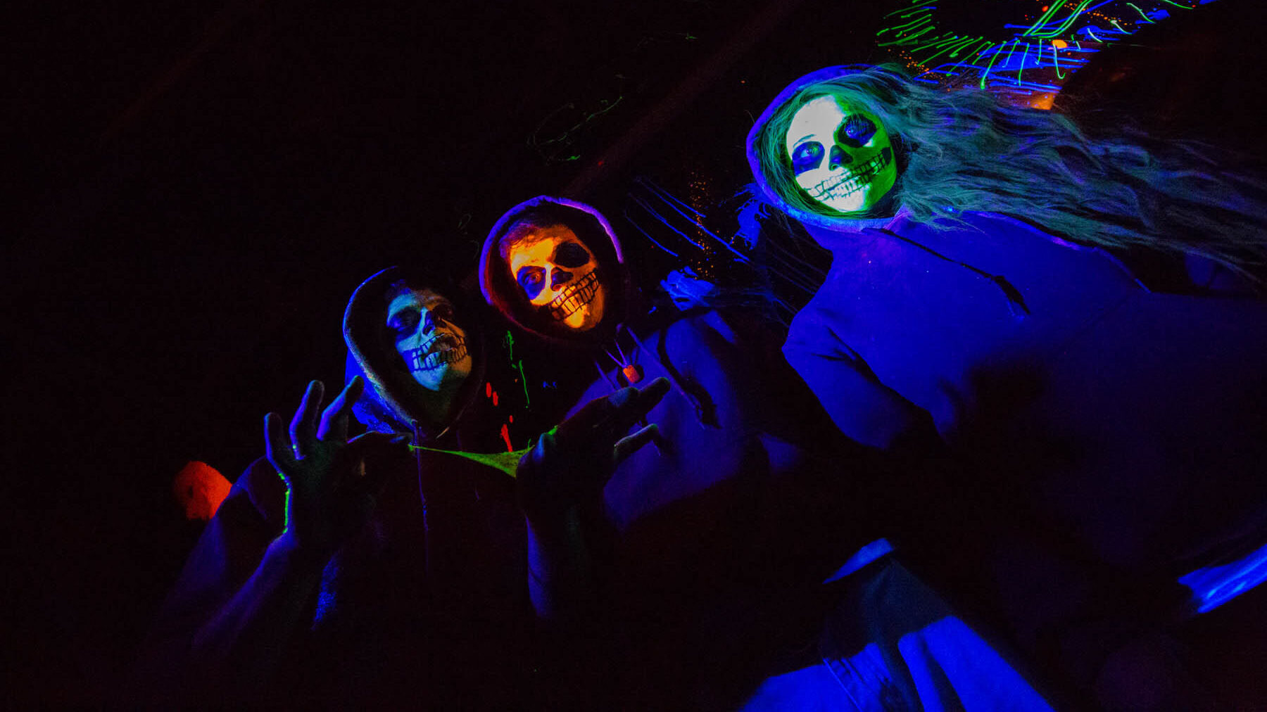 People dressed up as skeletons on a Poconos Halloween vacation.