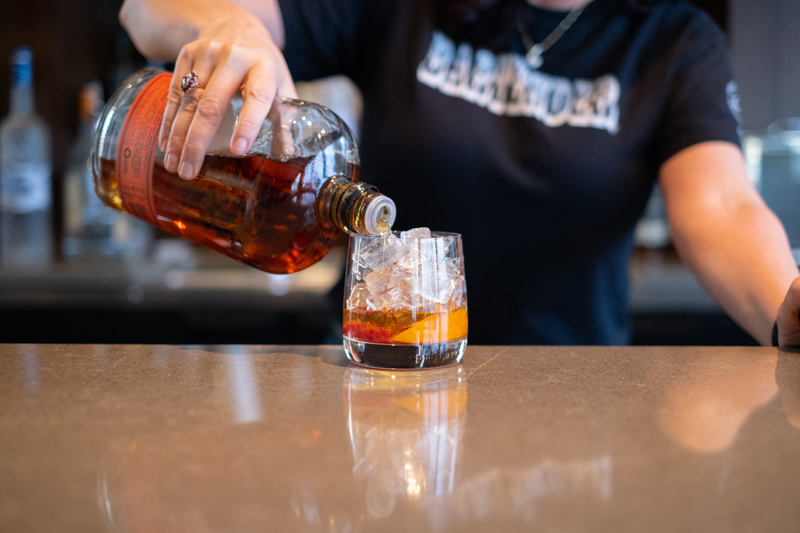 Bartender pouring cocktail.