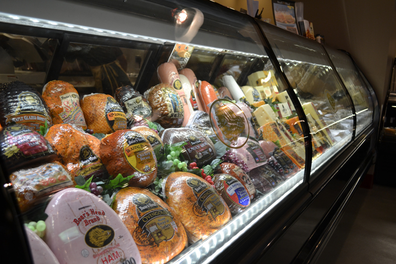 Grocery store meats section. Hams, Turkeys and salamis.