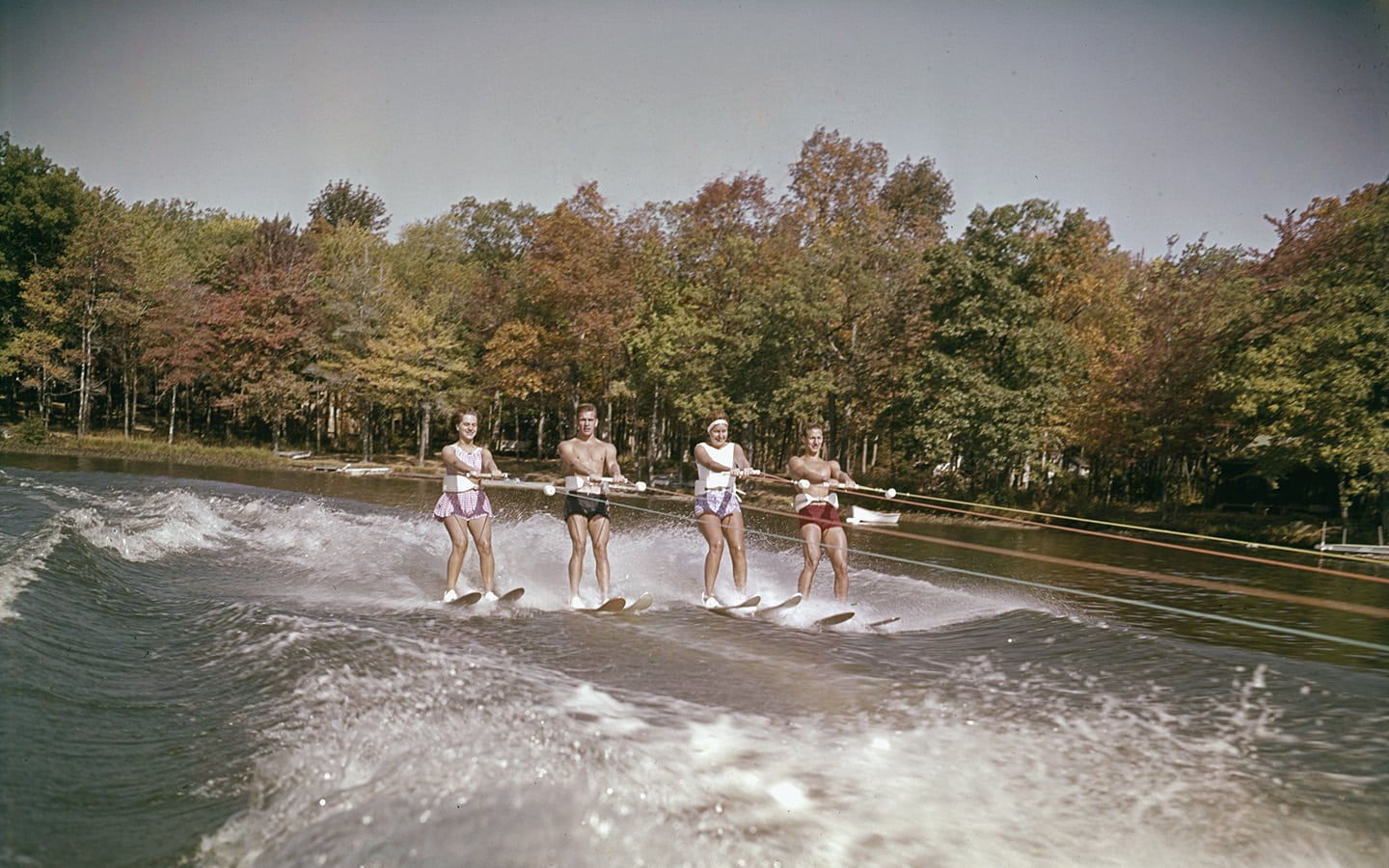 Historic photo of four waterskiers.